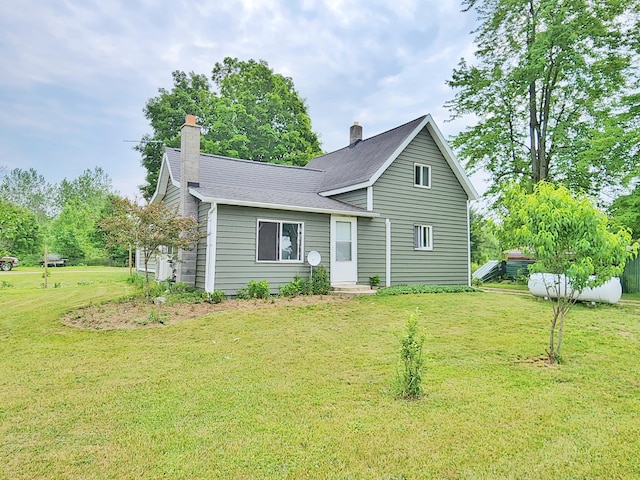350 S Catalpa Ave, White Cloud, MI 49349 - rear view of house with a chimney, a yard, and roof with shingles