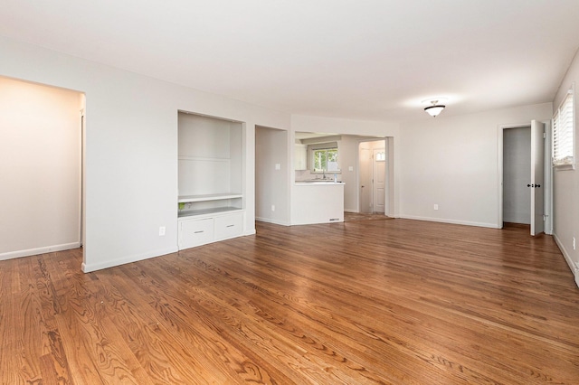 32530 Halmich Dr, Warren, MI 48092 - unfurnished living room with built in shelves and wood finished floors