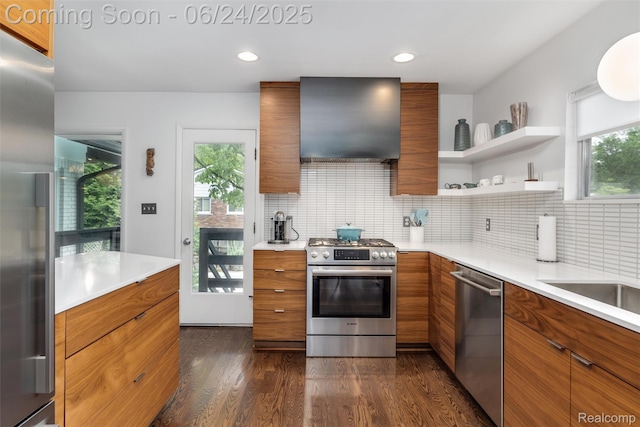 6895 Cedarbrook Dr, Bloomfield Hills, MI 48301 - kitchen with stainless steel appliances, wall chimney range hood, brown cabinetry, modern cabinets, and light countertops