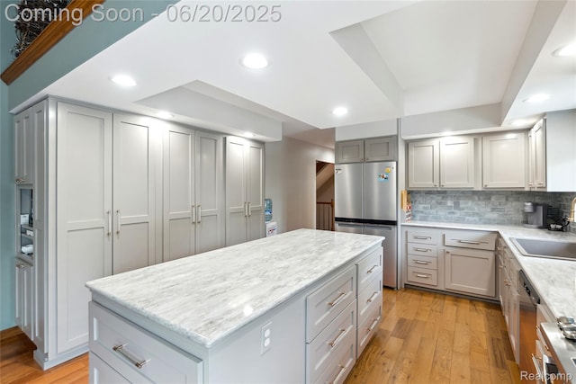 459 N Elms Rd, Flushing, MI 48433 - kitchen featuring appliances with stainless steel finishes, light wood-style floors, a center island, gray cabinetry, and backsplash