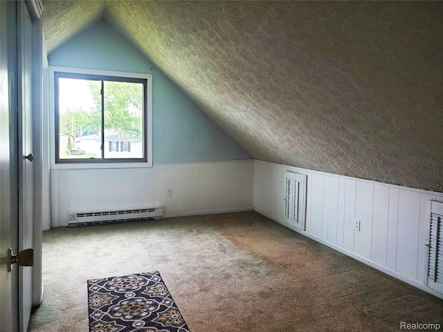 115 Choctaw Trl, Prudenville, MI 48651 - additional living space featuring baseboard heating, carpet floors, vaulted ceiling, a textured ceiling, and a wainscoted wall