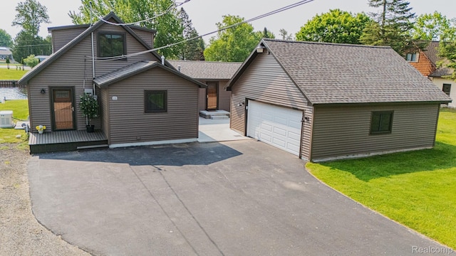 115 Choctaw Trl, Prudenville, MI 48651 - view of front of house with a front yard, roof with shingles, driveway, and an attached garage
