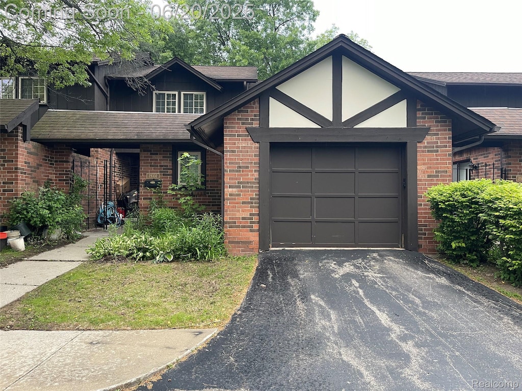 29332 Wellington Rd W, Southfield, MI 48034 - view of front of house with an attached garage, driveway, brick siding, and a shingled roof