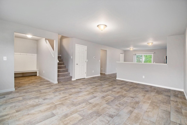 7216 Heartwood Ct, Portage, MI 49002 - unfurnished living room with stairs and wood finished floors