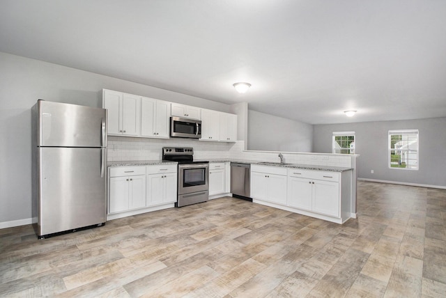 7216 Heartwood Ct, Portage, MI 49002 - kitchen featuring stainless steel appliances, light wood-style flooring, open floor plan, and white cabinets