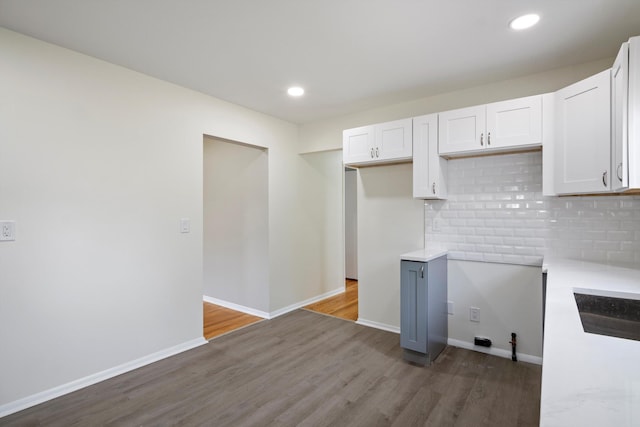 7710 Pelham Rd, Taylor, MI 48180 - kitchen featuring wood finished floors, decorative backsplash, white cabinetry, light countertops, and recessed lighting
