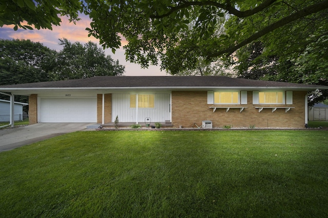 1653 Foye Dr, Jackson, MI 49203 - ranch-style home with an attached garage, brick siding, and a front lawn
