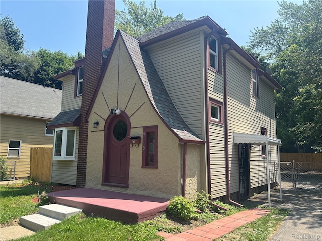 910 Spence St, Southfield, MI 48340 - view of front of property featuring a chimney, stucco siding, and a shingled roof