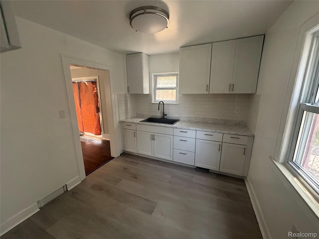 910 Spence St, Southfield, MI 48340 - kitchen featuring wood finished floors, decorative backsplash, and white cabinets