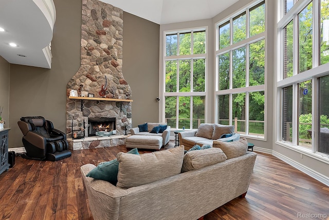 429 Hawk High Hill Rd, Metamora, MI 48455 - living area featuring a stone fireplace, a high ceiling, dark wood-style floors, and plenty of natural light