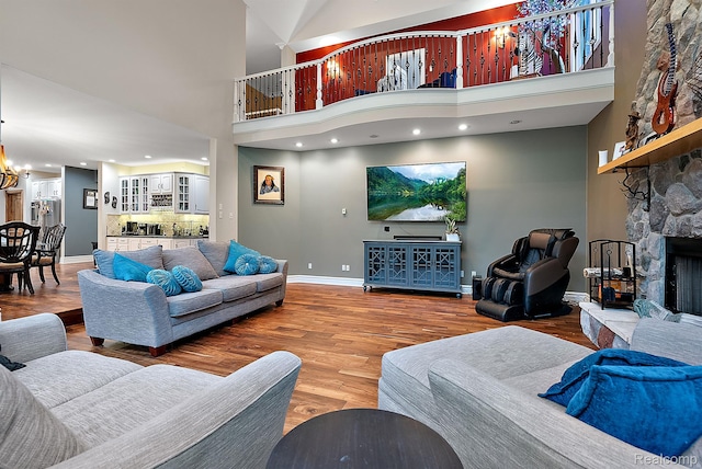 429 Hawk High Hill Rd, Metamora, MI 48455 - living room with a fireplace, a towering ceiling, wood finished floors, and a chandelier