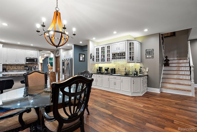 429 Hawk High Hill Rd, Metamora, MI 48455 - dining space featuring a chandelier, dark wood-style flooring, bar with sink, recessed lighting, and stairs
