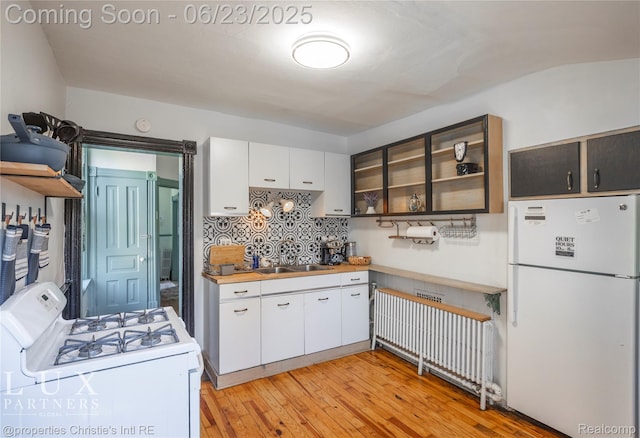 1200 Porter St, Detroit, MI 48226 - kitchen with white appliances, white cabinets, light wood-type flooring, and tasteful backsplash