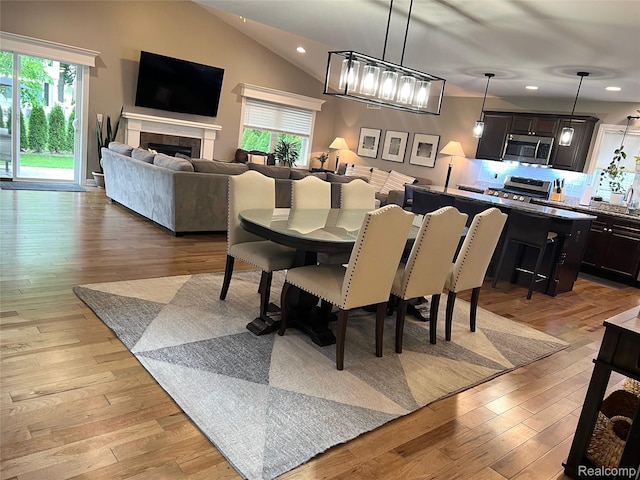 23540 Wilson Ave, Dearborn, MI 48128 - dining area featuring plenty of natural light, vaulted ceiling, recessed lighting, light wood finished floors, and a tile fireplace