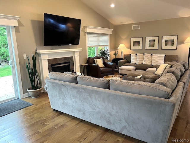 23540 Wilson Ave, Dearborn, MI 48128 - living room featuring vaulted ceiling, a tile fireplace, healthy amount of natural light, wood finished floors, and recessed lighting