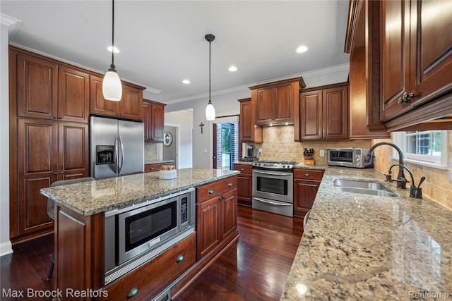 2534 Buckingham Ave, Birmingham, MI 48009 - kitchen featuring stainless steel appliances, crown molding, a kitchen island, backsplash, and light stone counters