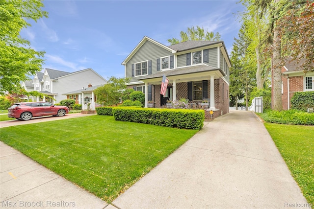2534 Buckingham Ave, Birmingham, MI 48009 - view of front of house with covered porch, driveway, brick siding, and a front lawn