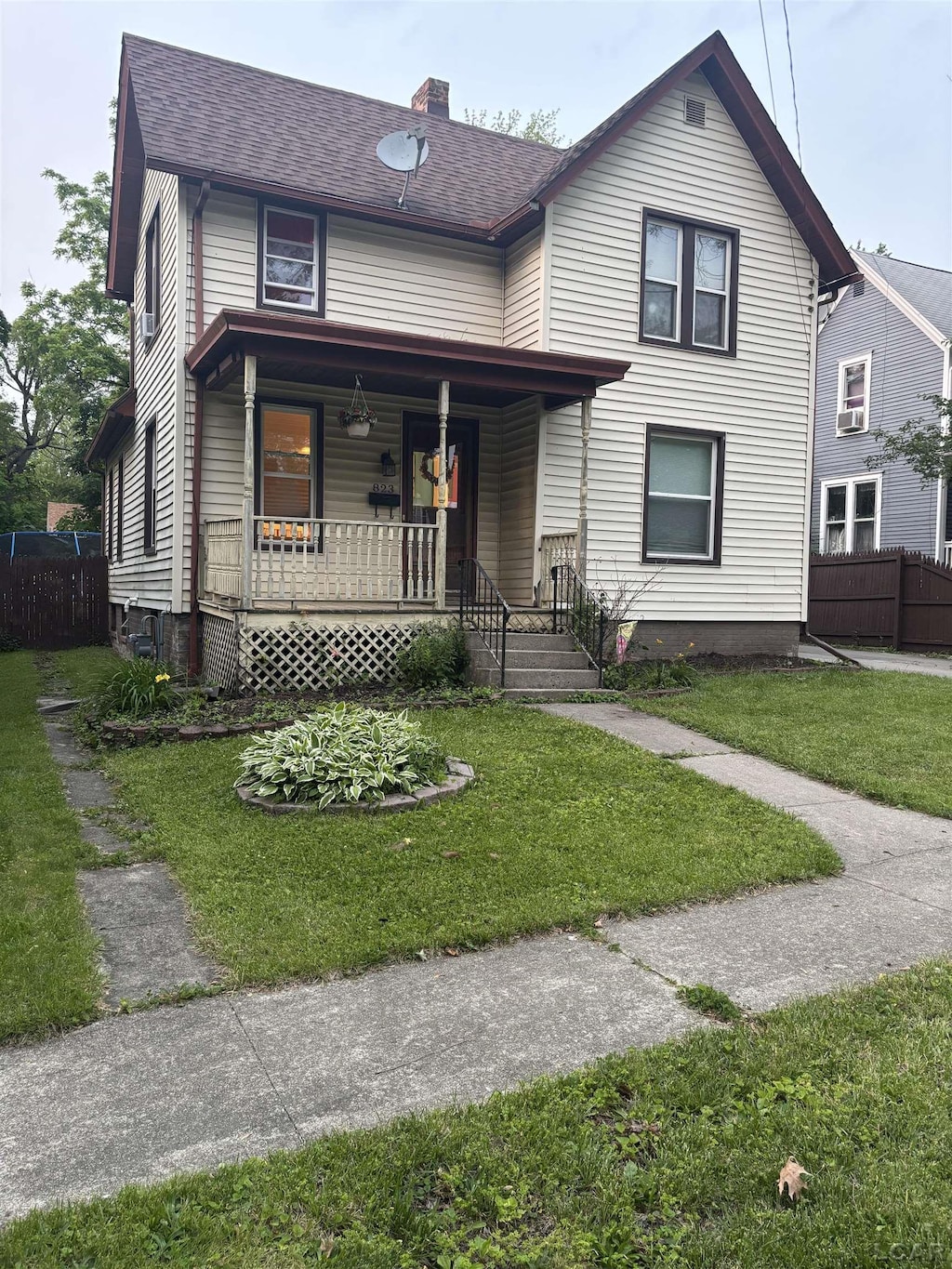 823 E Hunt St, Adrian, MI 49221 - view of front facade featuring covered porch, a chimney, and a shingled roof