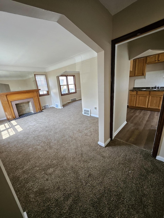 18242 Mendota St, Detroit, MI 48221 - unfurnished living room with dark colored carpet and a fireplace