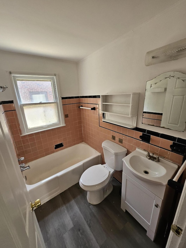 18242 Mendota St, Detroit, MI 48221 - bathroom featuring tile walls, wood finished floors, a garden tub, vanity, and a wainscoted wall