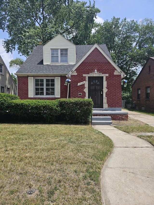 18242 Mendota St, Detroit, MI 48221 - view of front of house with brick siding, a front lawn, and a shingled roof