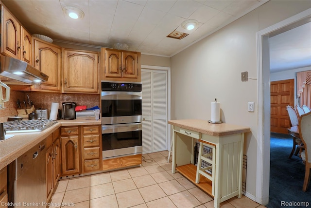 637 Arthur Ave, Pontiac, MI 48341 - kitchen featuring stainless steel appliances, under cabinet range hood, light countertops, decorative backsplash, and light tile patterned floors