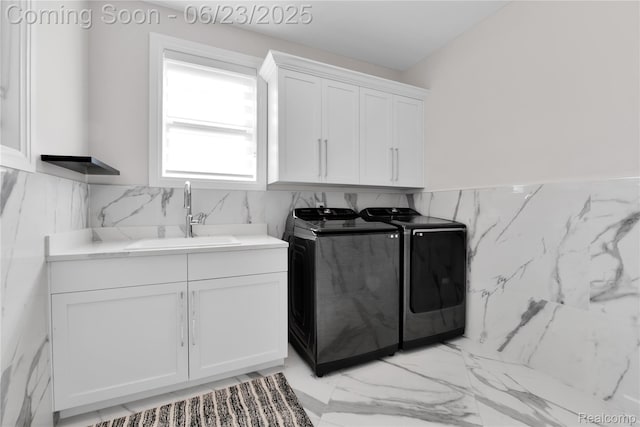 56727 Via Carlotta, Shelby Twp, MI 48042 - laundry room featuring washer and dryer, cabinet space, tile walls, a wainscoted wall, and light marble finish floors