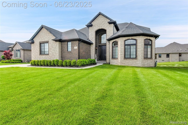 56727 Via Carlotta, Shelby Twp, MI 48042 - french country inspired facade with stone siding, a front yard, and roof with shingles