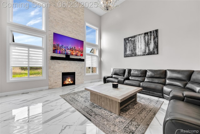 56727 Via Carlotta, Shelby Twp, MI 48042 - living room with a towering ceiling, marble finish flooring, healthy amount of natural light, a stone fireplace, and a chandelier