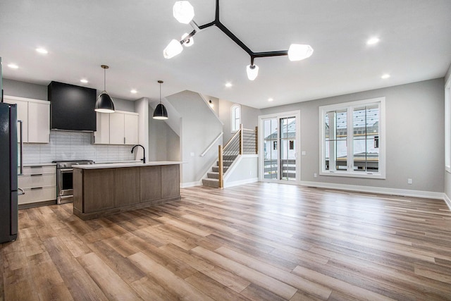 994 Harbor Dr E, Saint Joseph, MI 49085 - kitchen featuring stainless steel stove, extractor fan, light wood-style flooring, tasteful backsplash, and recessed lighting
