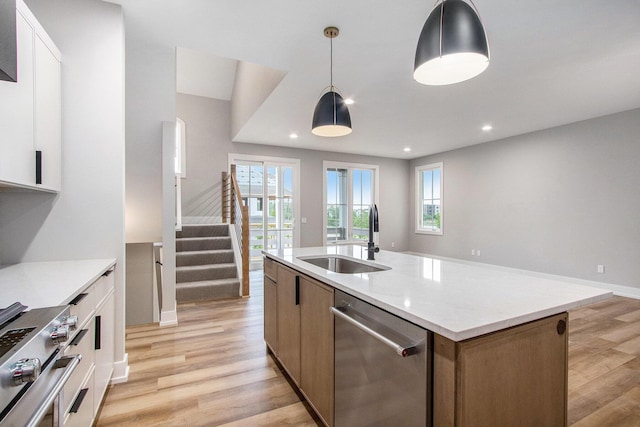 994 Harbor Dr E, Saint Joseph, MI 49085 - kitchen with appliances with stainless steel finishes, light wood finished floors, a center island with sink, hanging light fixtures, and recessed lighting