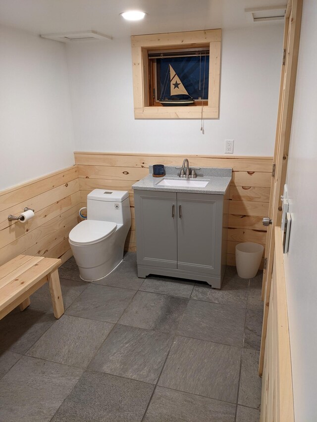 539 Sunset Ln, East Lansing, MI 48823 - bathroom with wainscoting, wooden walls, and vanity