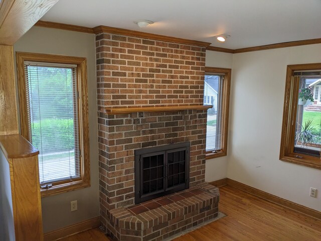 539 Sunset Ln, East Lansing, MI 48823 - unfurnished living room featuring a fireplace, wood finished floors, plenty of natural light, and crown molding