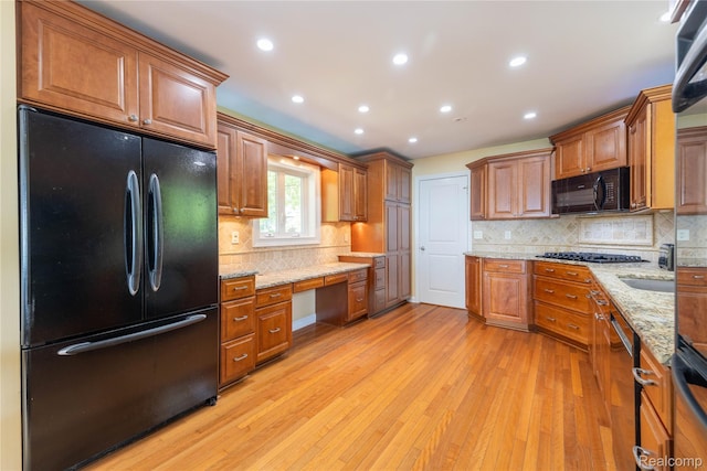 19891 Parke Ln, Grosse Ile, MI 48138 - kitchen featuring black appliances, built in desk, light wood finished floors, brown cabinetry, and recessed lighting