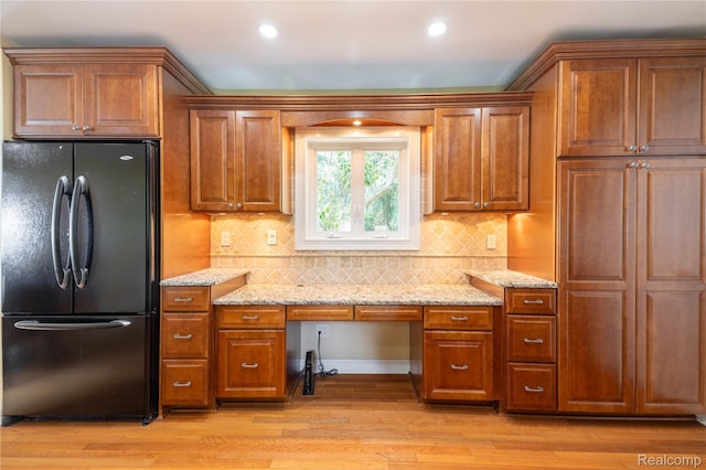 19891 Parke Ln, Grosse Ile, MI 48138 - kitchen with freestanding refrigerator, brown cabinetry, light wood finished floors, light stone counters, and recessed lighting