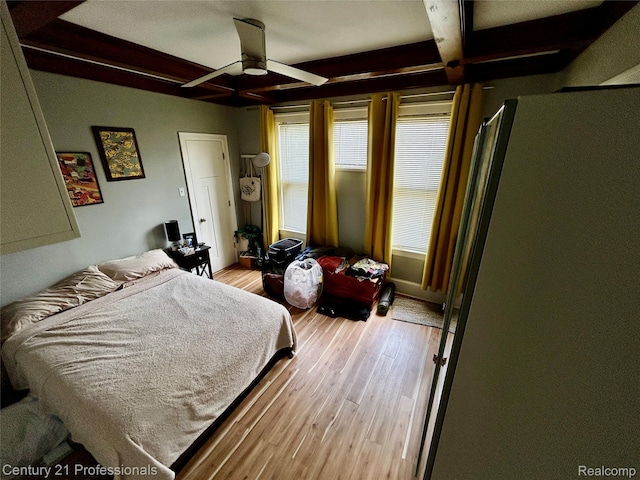 2118 Vinewood St, Detroit, MI 48216 - bedroom featuring beam ceiling, light wood-type flooring, freestanding refrigerator, and a ceiling fan