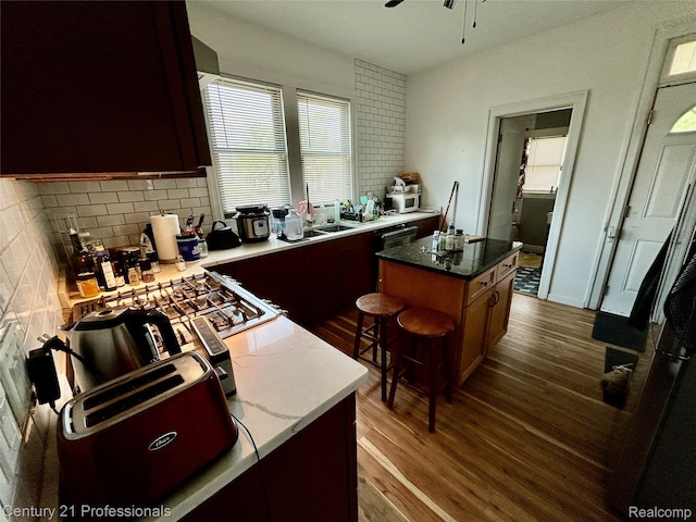 2118 Vinewood St, Detroit, MI 48216 - kitchen featuring dark wood finished floors, backsplash, a kitchen island, a ceiling fan, and light stone countertops