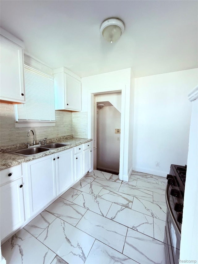 9941 Minock St, Detroit, MI 48228 - kitchen with stainless steel gas range, light marble finish floors, white cabinets, and tasteful backsplash