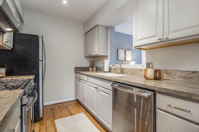1320 Patricia Ave, Ann Arbor, MI 48103 - kitchen featuring appliances with stainless steel finishes, wall chimney exhaust hood, light wood-type flooring, and white cabinets