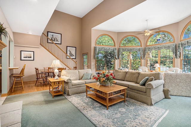 11683 Fair Lk, Delton, MI 49046 - living area featuring plenty of natural light, stairway, a ceiling fan, a towering ceiling, and carpet
