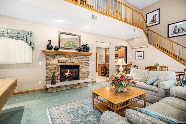 11683 Fair Lk, Delton, MI 49046 - living area with carpet flooring, stairway, a stone fireplace, and a high ceiling