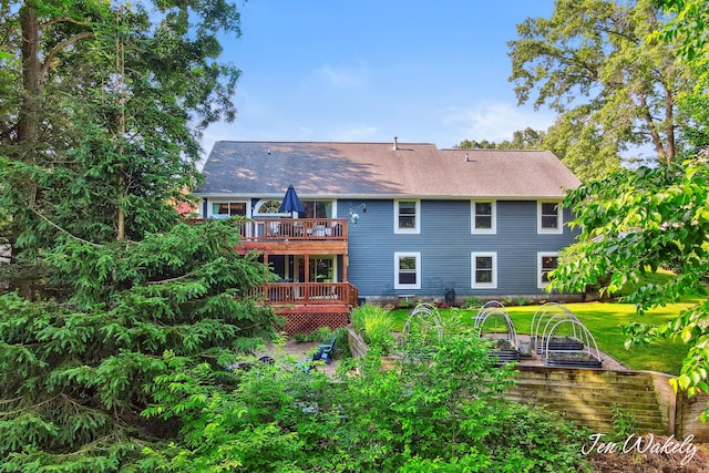 278 Caravan Rd, Norton Shores, MI 49441 - back of property with a wooden deck, a vegetable garden, and a lawn