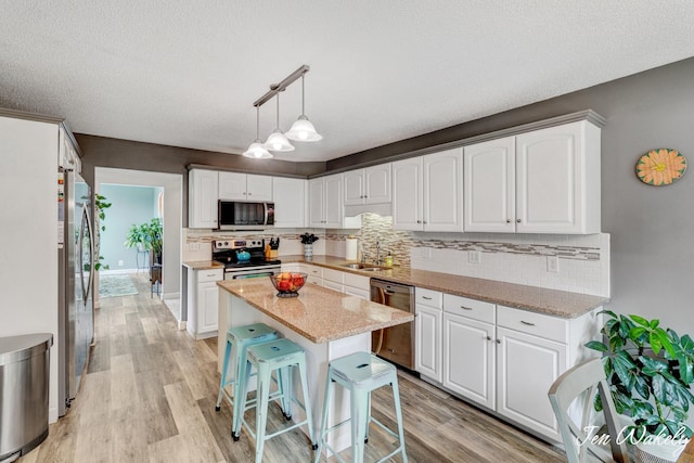 278 Caravan Rd, Norton Shores, MI 49441 - kitchen with appliances with stainless steel finishes, tasteful backsplash, white cabinets, and a textured ceiling