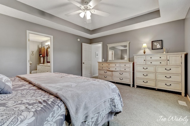 278 Caravan Rd, Norton Shores, MI 49441 - bedroom featuring light carpet, ensuite bath, ceiling fan, and a raised ceiling