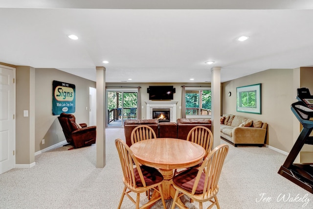 278 Caravan Rd, Norton Shores, MI 49441 - dining space featuring carpet, recessed lighting, a glass covered fireplace, and decorative columns