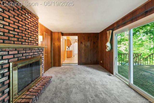12260 Dollar Lake Dr, Fenton, MI 48430 - unfurnished living room featuring plenty of natural light, wood walls, carpet, and a brick fireplace