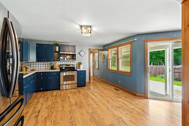 8368 N 46th St, Augusta, MI 49012 - kitchen featuring appliances with stainless steel finishes, blue cabinets, light countertops, tasteful backsplash, and light wood-style floors