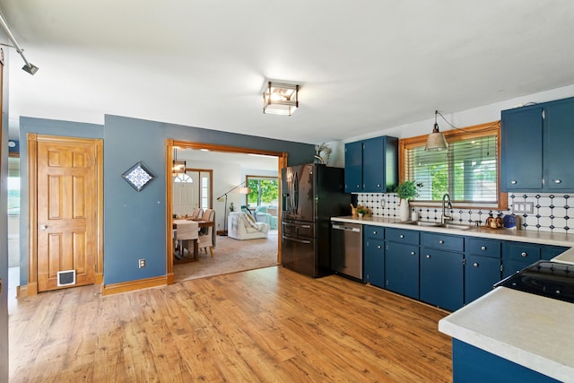 8368 N 46th St, Augusta, MI 49012 - kitchen with stainless steel dishwasher, black fridge, blue cabinets, and light wood-style flooring
