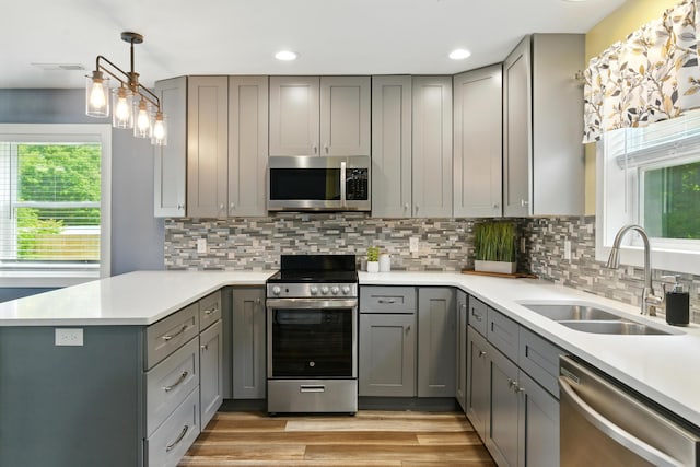 8368 N 46th St, Augusta, MI 49012 - kitchen featuring appliances with stainless steel finishes, gray cabinets, a peninsula, light countertops, and recessed lighting