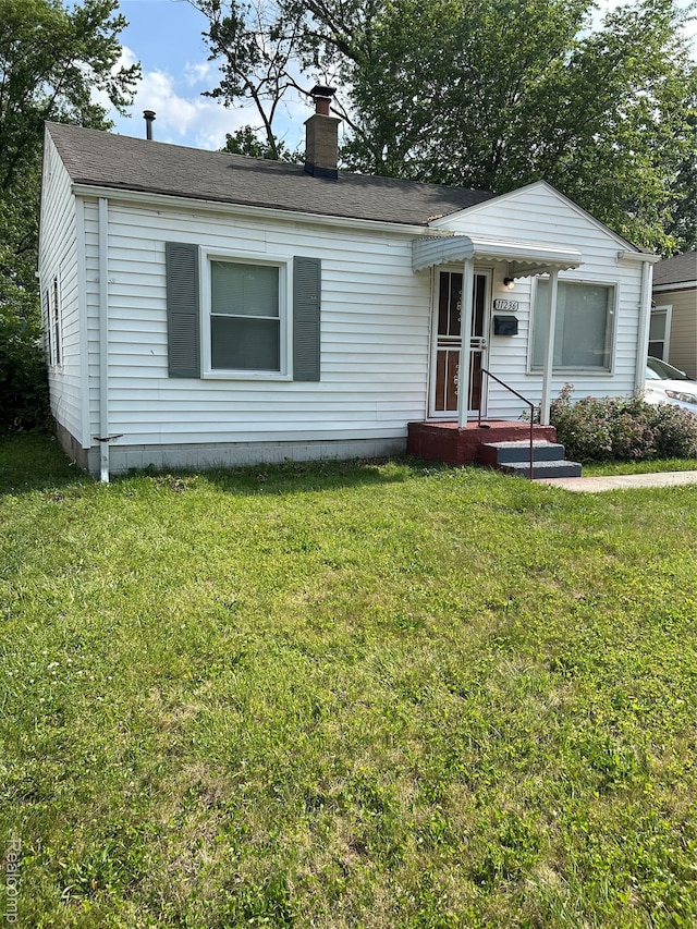 11236 Studebaker Ave, Warren, MI 48089 - view of front of house with a chimney, a front lawn, and roof with shingles
